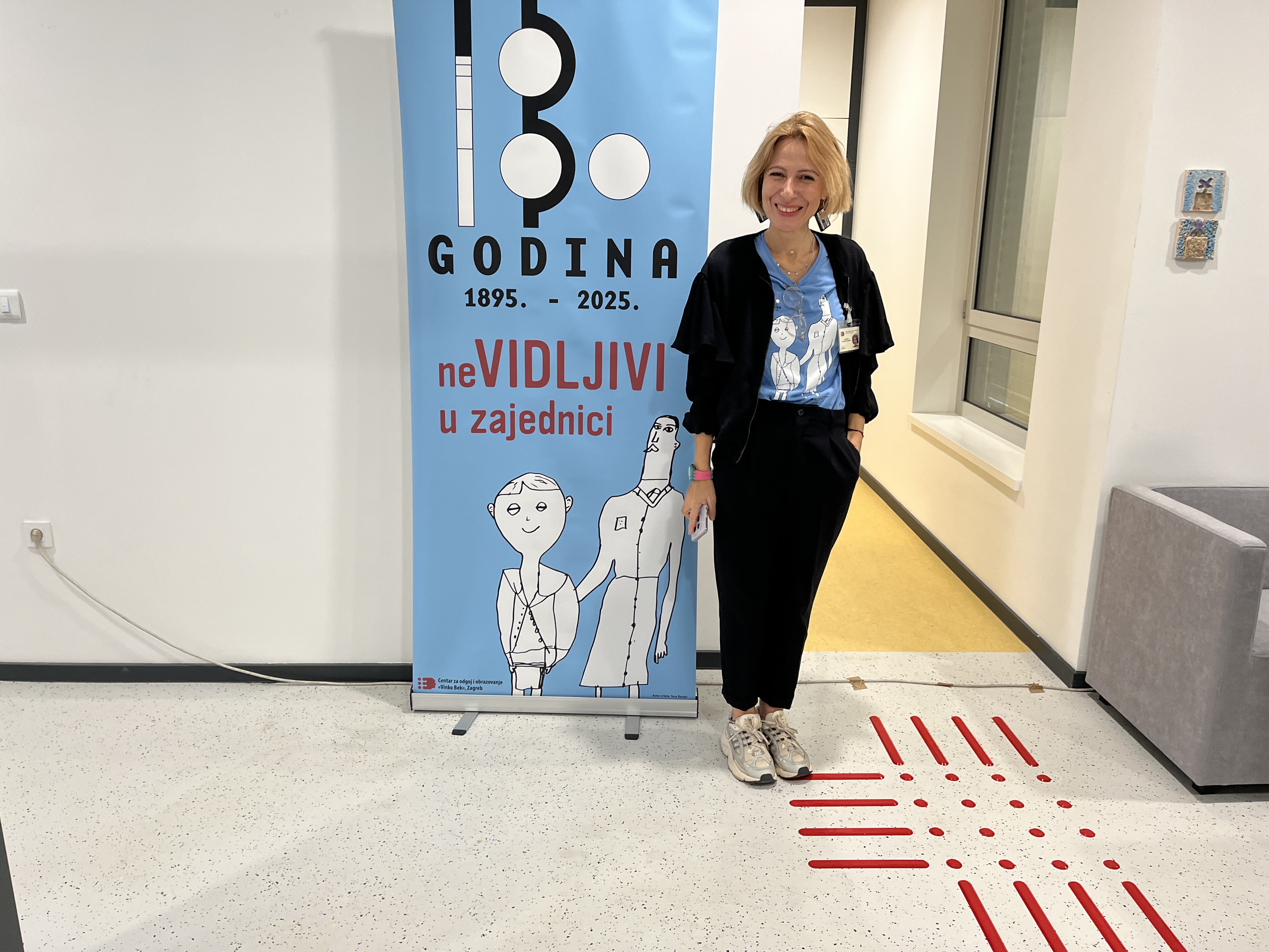 Stručna radnica ispred plakata za 130 godina Centra