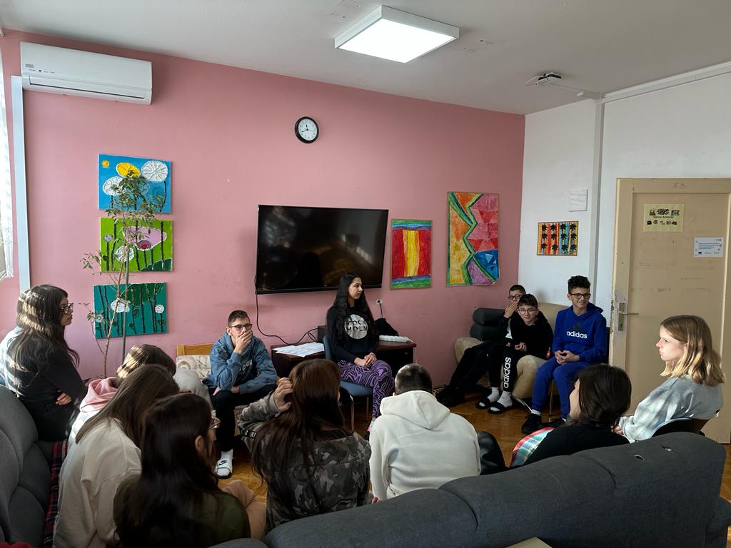 Na slici se nalaze učenici koji su došli u naš Centar te sudjeluju u radionici upoznavanja. Na slici je 12 učenika koji sjede u krugu.