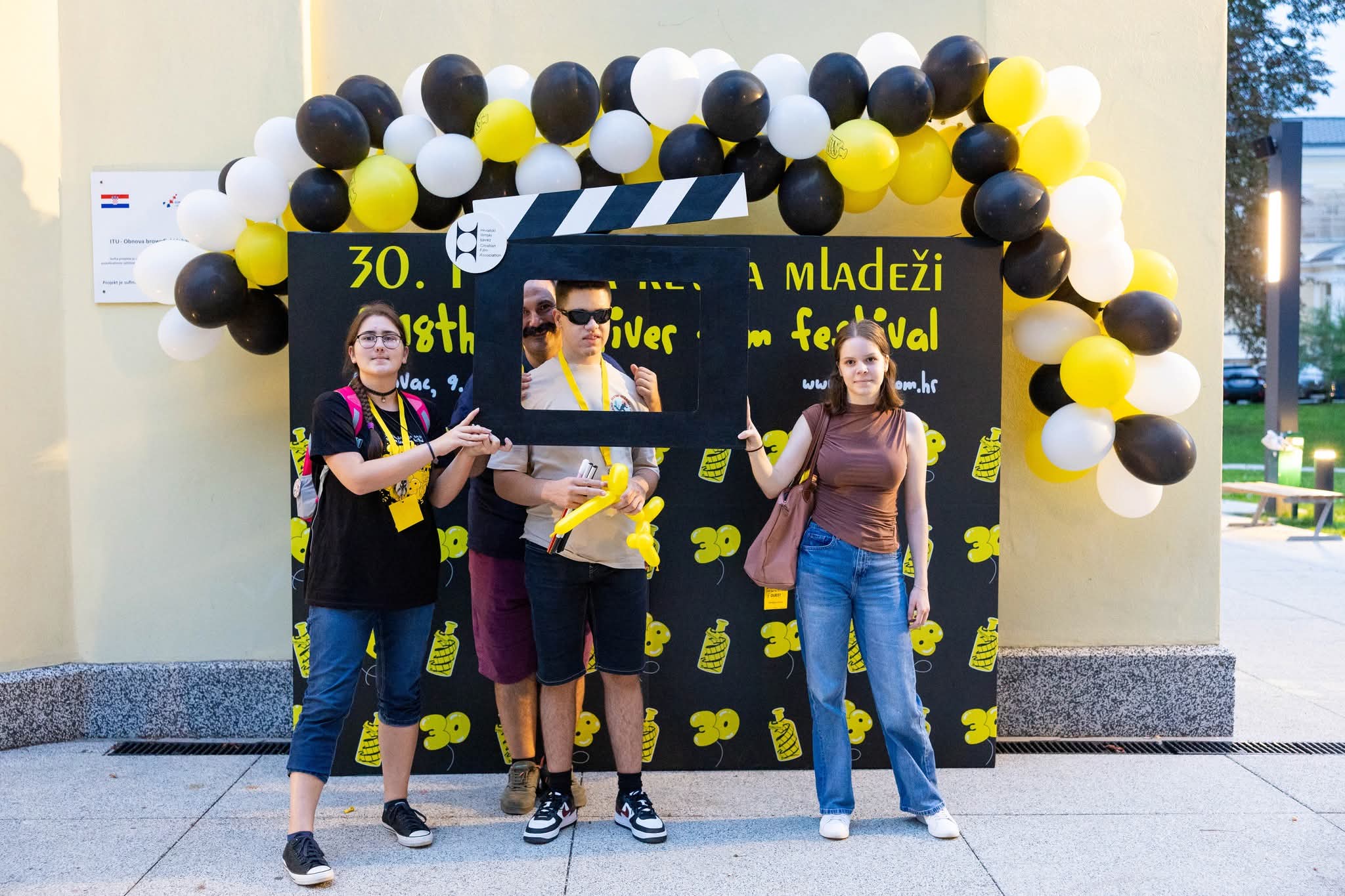 Deni, Danijela, prof Mirko i sudionica festivala ispred glavnog ulaza u kino i ploče s natpisom festivala